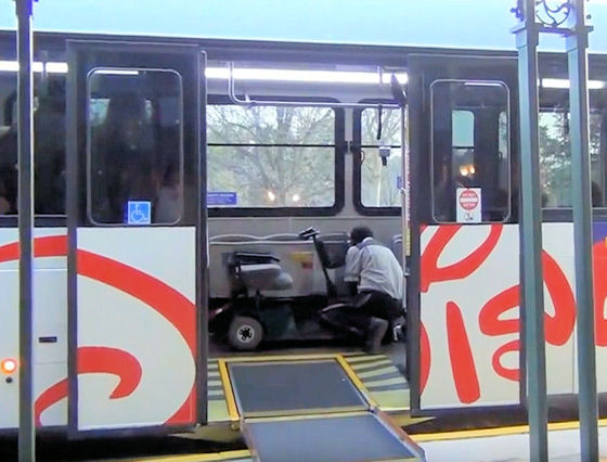 Driver securing a mobility scooter on a Disney World bus
