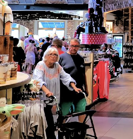 A Guest Using A Rollator Inside The World Of Disney Gift Shop