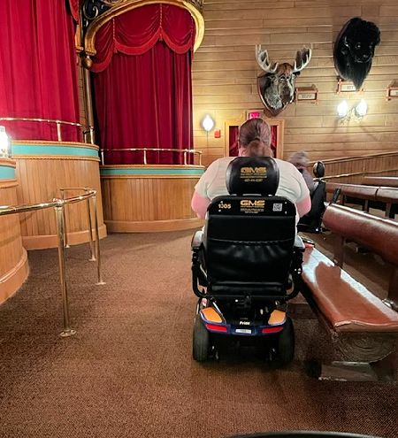 Another image of a mobility scooter entering into Grizzly Hall awaiting the Country Bear Jamboree show.